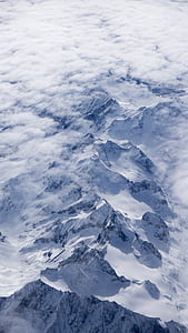 aerial photography of glacier mountain covered by clouds thumbnail