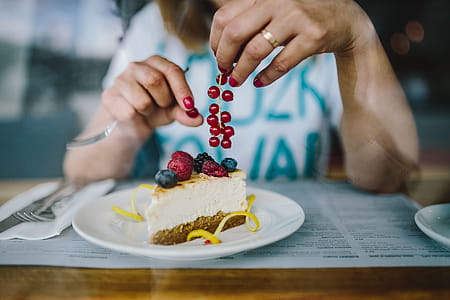 Woman Enjoying Cheese Cake and a Coffee with Fruits in a Cafeteria thumbnail