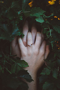 hand with ring grabbing hand on top of grass thumbnail