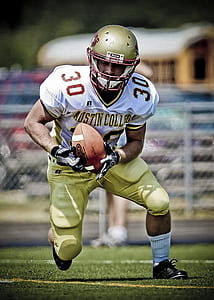 football player man holding ball in open field thumbnail