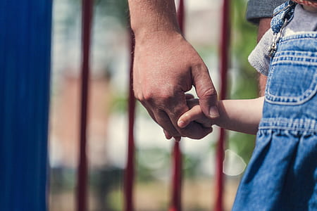 selective focus photography of person holding children's hand thumbnail
