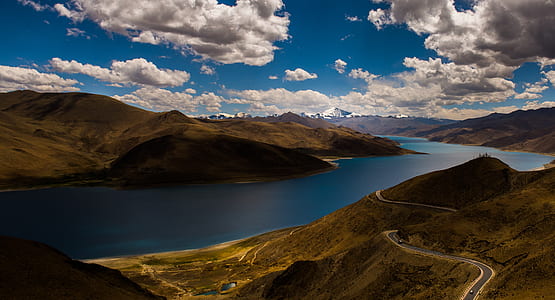 high-angle photography of body of water between mountain thumbnail