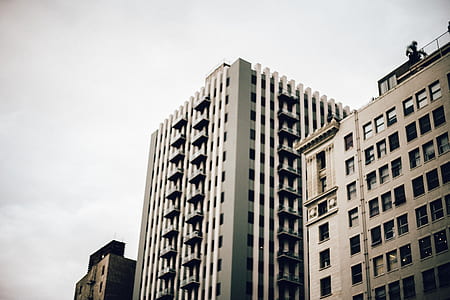 white city building under white clouds thumbnail