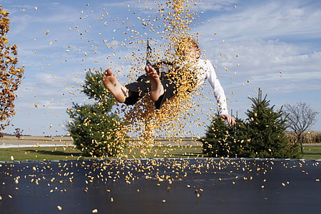 boy bouncing on black trampoline during daytime thumbnail