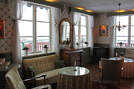 round table covered with brown cloth beside glass window thumbnail