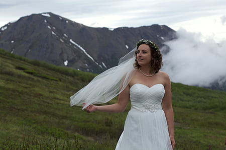 Woman Standing on Grass Wearing White Wedding Dress thumbnail