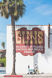 man walking in front of Guns shop thumbnail