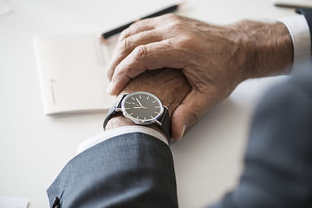 man wearing silver-colored watch with black strap thumbnail
