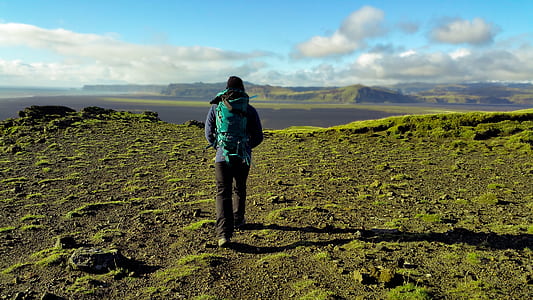 Person in Green Coat Walking on Mountain thumbnail