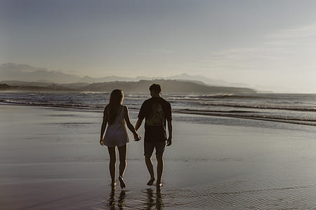 man and holding hands while walking on breach thumbnail