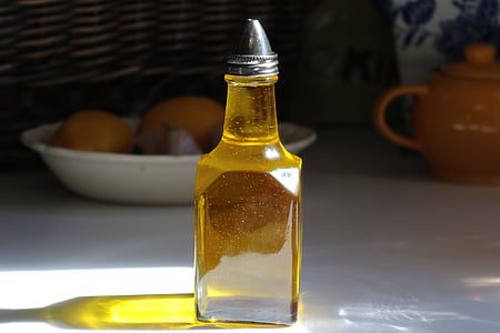 clear glass bottled olive on white wooden table thumbnail