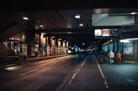 two person walking beside the road during nighttime thumbnail