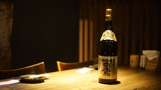 low-light photo of bottle on brown table thumbnail