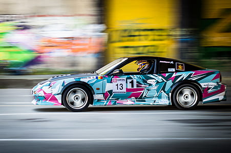 time lapse photography of multicolored racing vehicle on road thumbnail