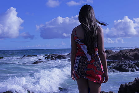 woman in red mini dress standing near sea during daytime thumbnail