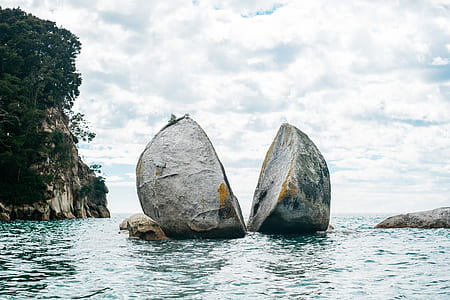 two gray boulder on body of water at daytime thumbnail
