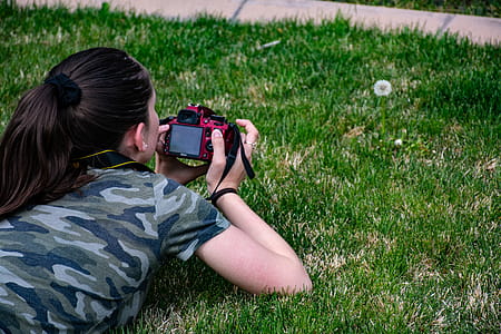 Woman in Camouflage T-shirt Holding Dslr Camera thumbnail