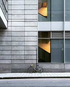 grey bicycle parked near grey concrete building during daytime thumbnail
