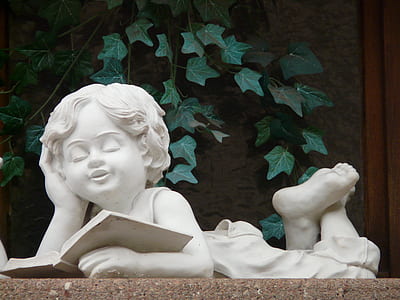 girl reading book statuette on brown surface thumbnail