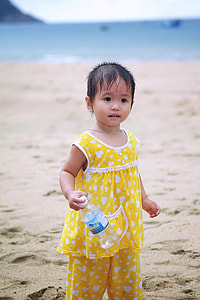 girl holding plastic bottle on shoreline thumbnail
