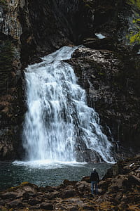Man Standing Near Waterfalls thumbnail