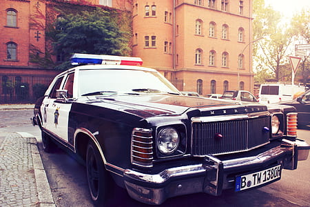 black and white police car near parking lot during daytime thumbnail