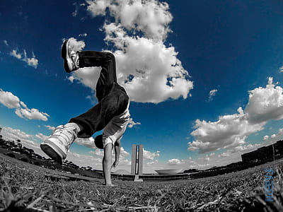 low angle photography of man in white shirt doing cartwheel thumbnail