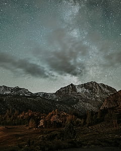 photography of brown and gray mountains under milky way thumbnail