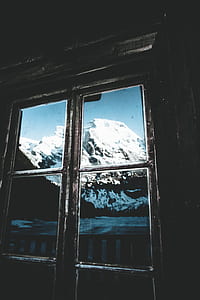 snowy mountain viewed on black framed window thumbnail