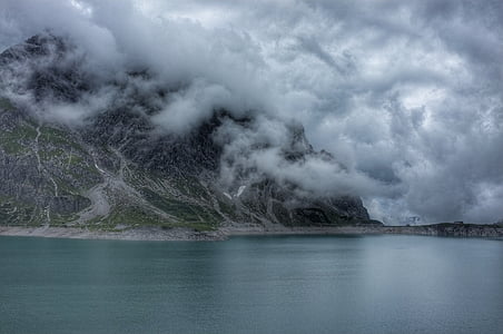 mountain near water with clouds thumbnail