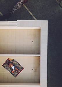 aerial photography of man lying on multicolored area rug on roof top thumbnail