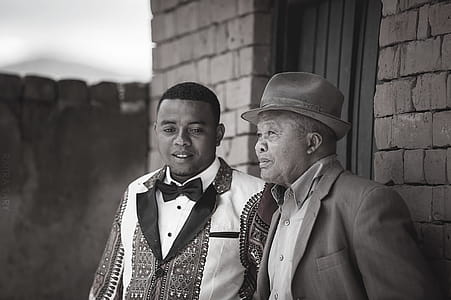 Gray Scale Photo of Two Men Wearing Coats thumbnail
