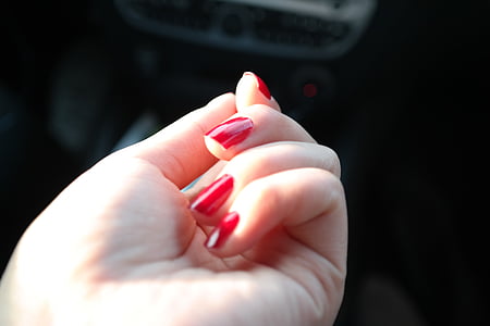woman's hand with red manicure thumbnail