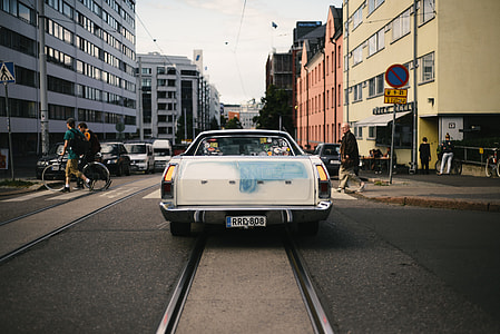 classic white car on road near buildings thumbnail