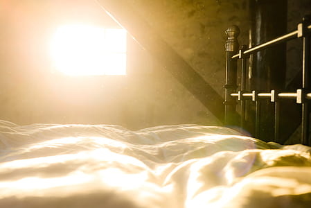 white white bed sheet on black metal bed frame thumbnail