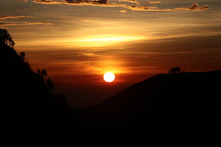 silhouette of mountain under cloudy sky photo taken during sunset thumbnail