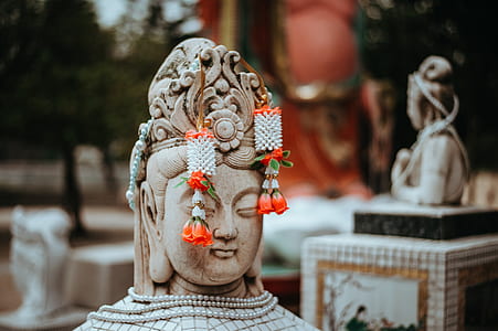 pair of white-and-red drop earrings on Buddha statue thumbnail