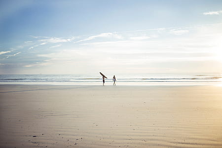 two person standing on front of ocean under blue sky thumbnail