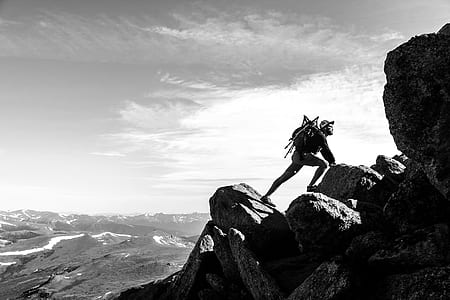 grayscale photography of man climbing on mountain thumbnail
