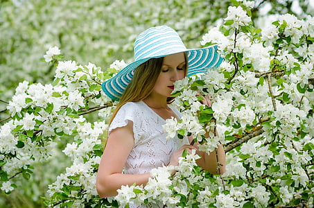 woman wearing white short-sleeved top and blue sun hat thumbnail