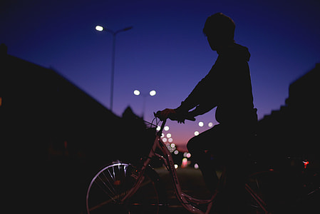 silhouette of person riding bicycle during night time thumbnail