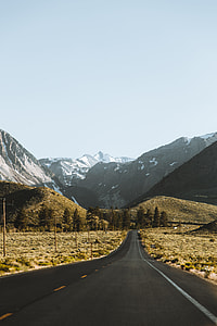 landscape photography of main road surrounded by mountains covered with ice under clear sky during day time thumbnail