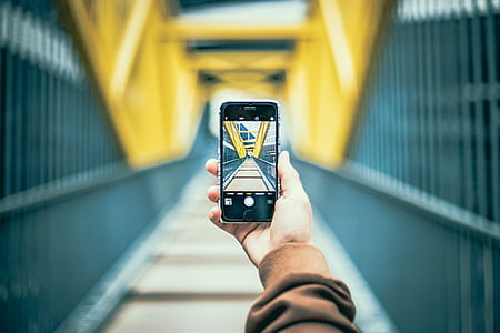 person holding space gray iPhone 6 taking photo of bridge thumbnail