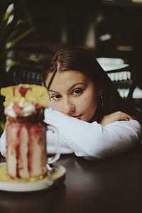 woman in white long-sleeved shirt leaning on table thumbnail