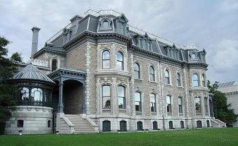 beige and gray building in front of grass field thumbnail