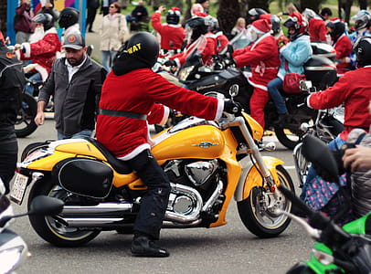Person in Santa Suit Riding Yellow Cruiser Motorcycle thumbnail