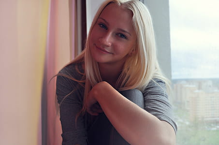 woman in grey 3/4 sleeved shirt near window thumbnail