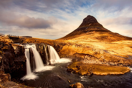 landscape timelapse photography of waterfalls under nimbus clouds during daytime thumbnail