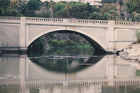gray bridge near green leafed trees during daytime thumbnail