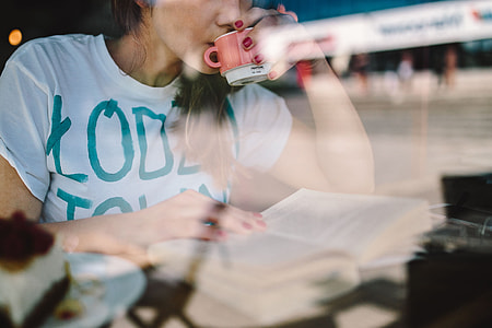 Woman reading book at coffee shop thumbnail